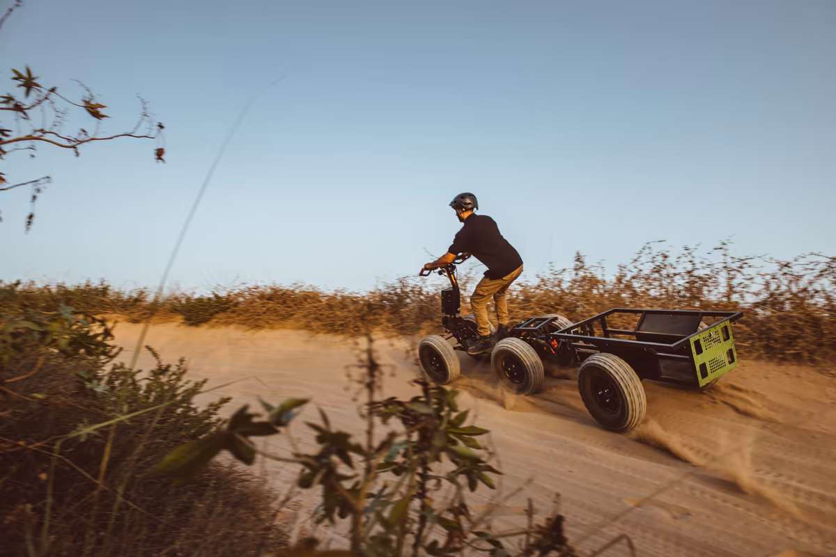 Rider towing an EZ Cart along a dusty dirt track, viewed from behind
